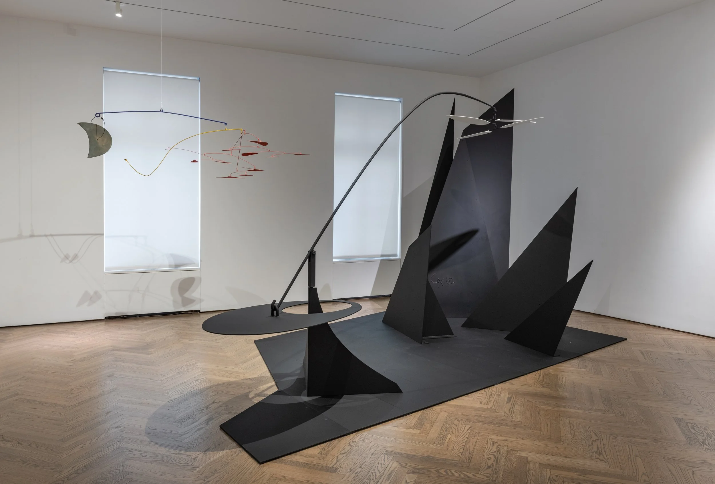 Calder, Install with Horizontal Red Moon Gong and Clouds over Mountain.jpeg