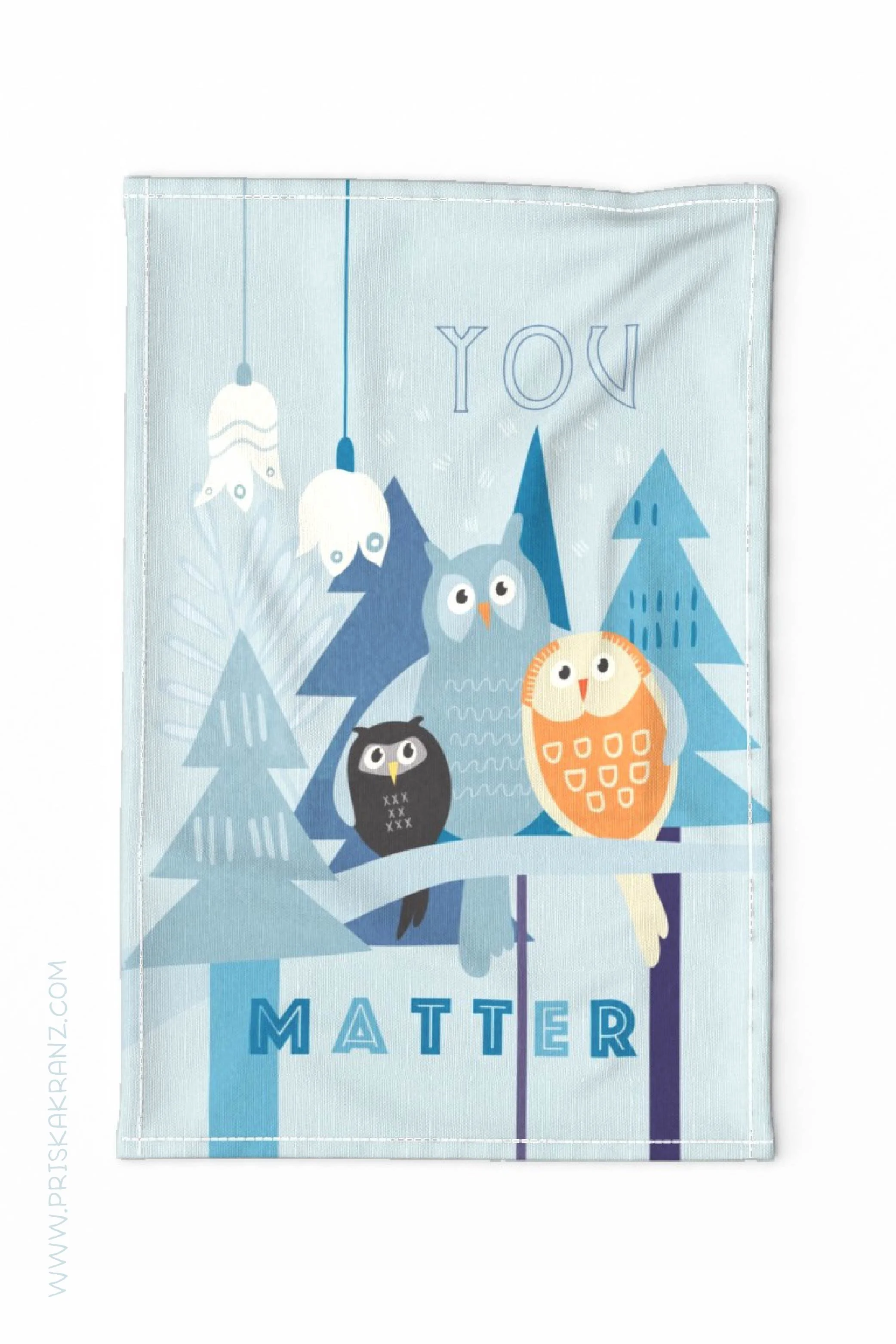 Tea towel featuring a whimsical illustration of three owls sitting on a branch among blue pine trees with hanging flowers and the phrase “You Matter.”