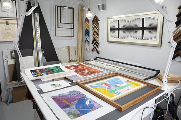 The working table, artwork and frame samples in my home studio in Nunhead