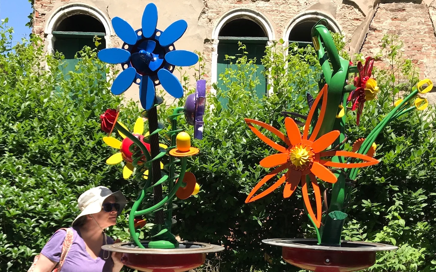 Nityatara stops to smell the flowers at a special art exhibit in the parks of Venice