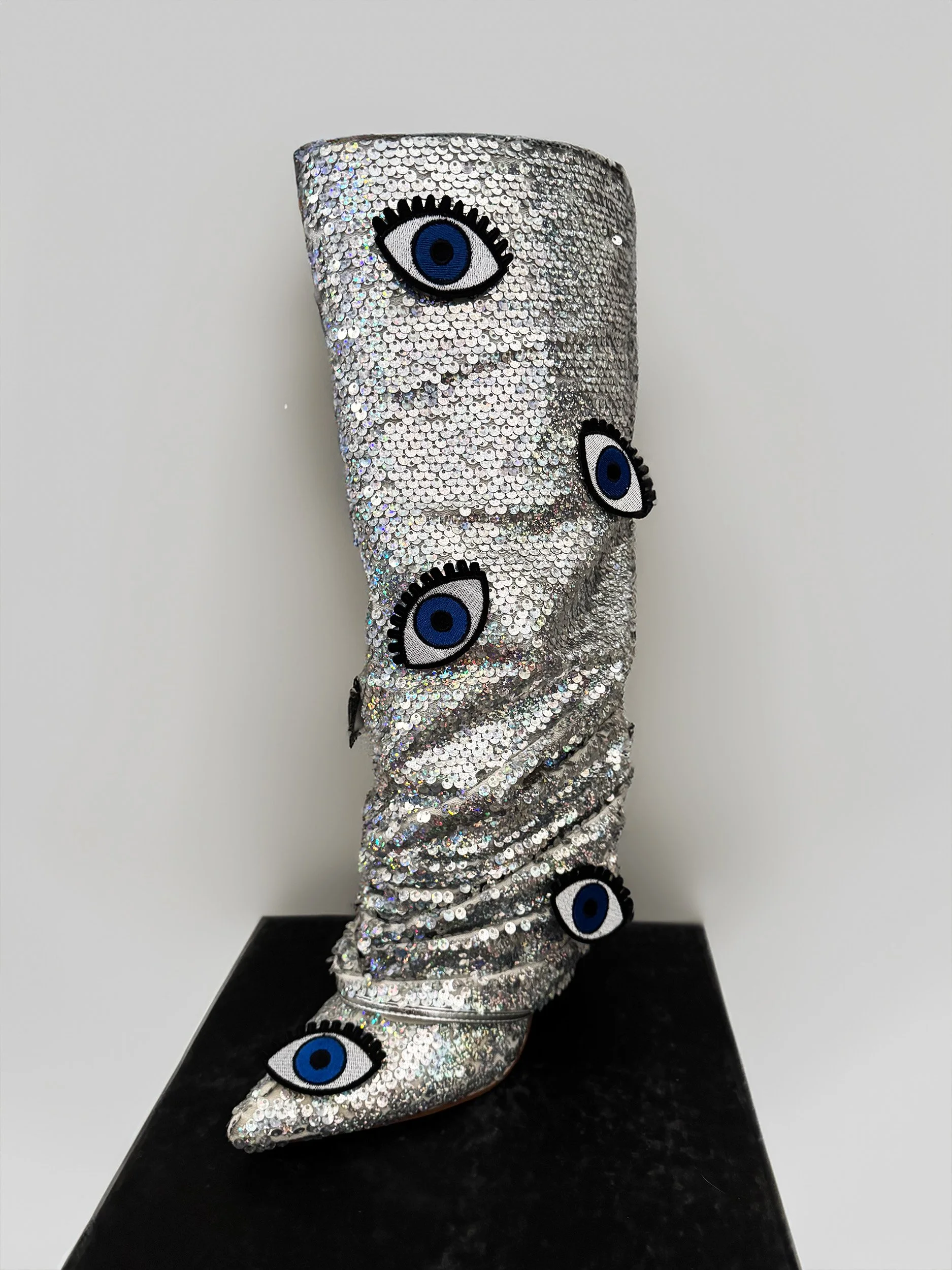 One-of-a-kind silver sequin boots embellished with embroidered evil eye patches, designed by artist Charity Huether. Mid-calf stiletto heel, size 8.5.
