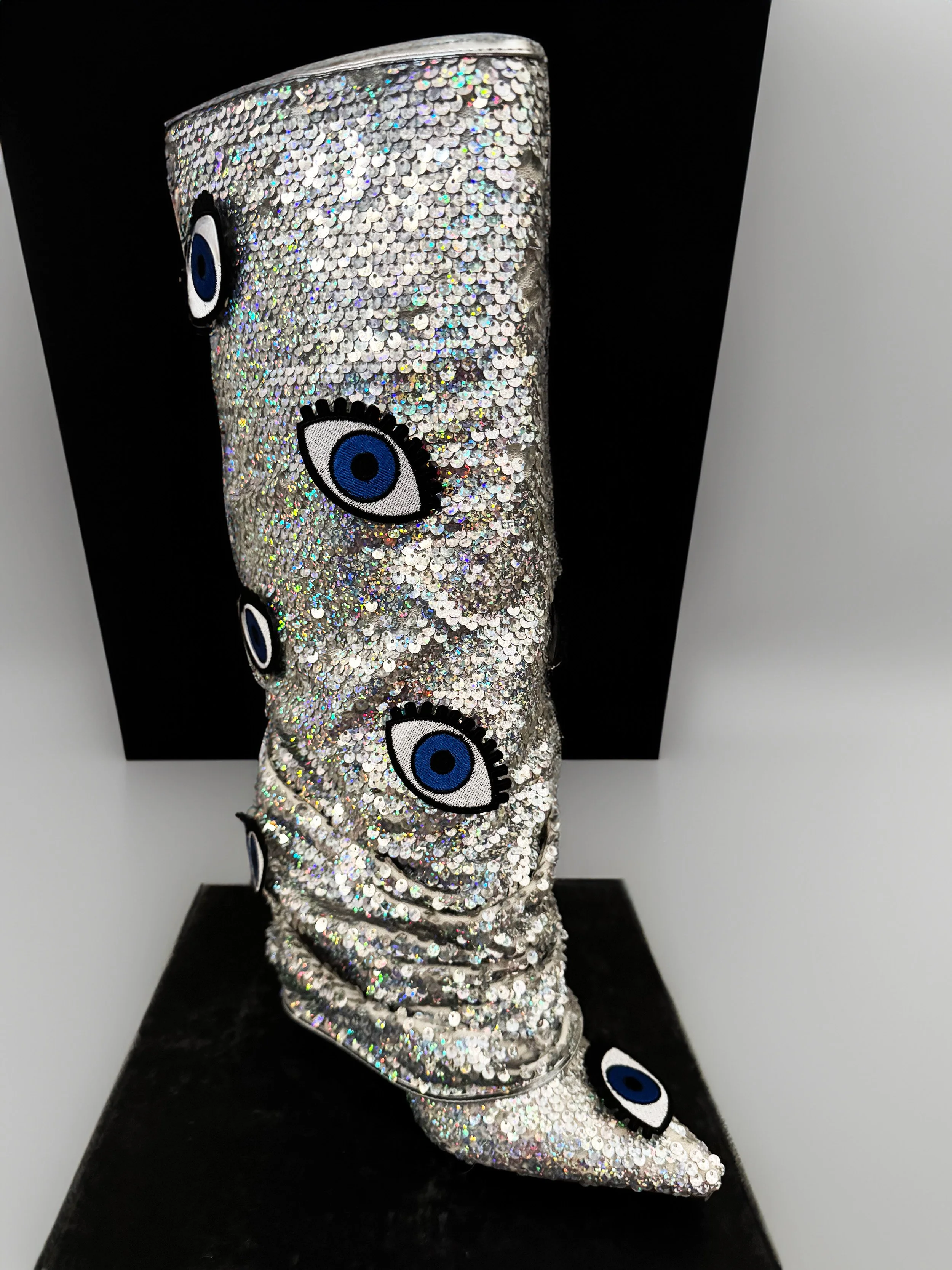 One-of-a-kind silver sequin boots embellished with embroidered evil eye patches, designed by artist Charity Huether. Mid-calf stiletto heel, size 8.5.