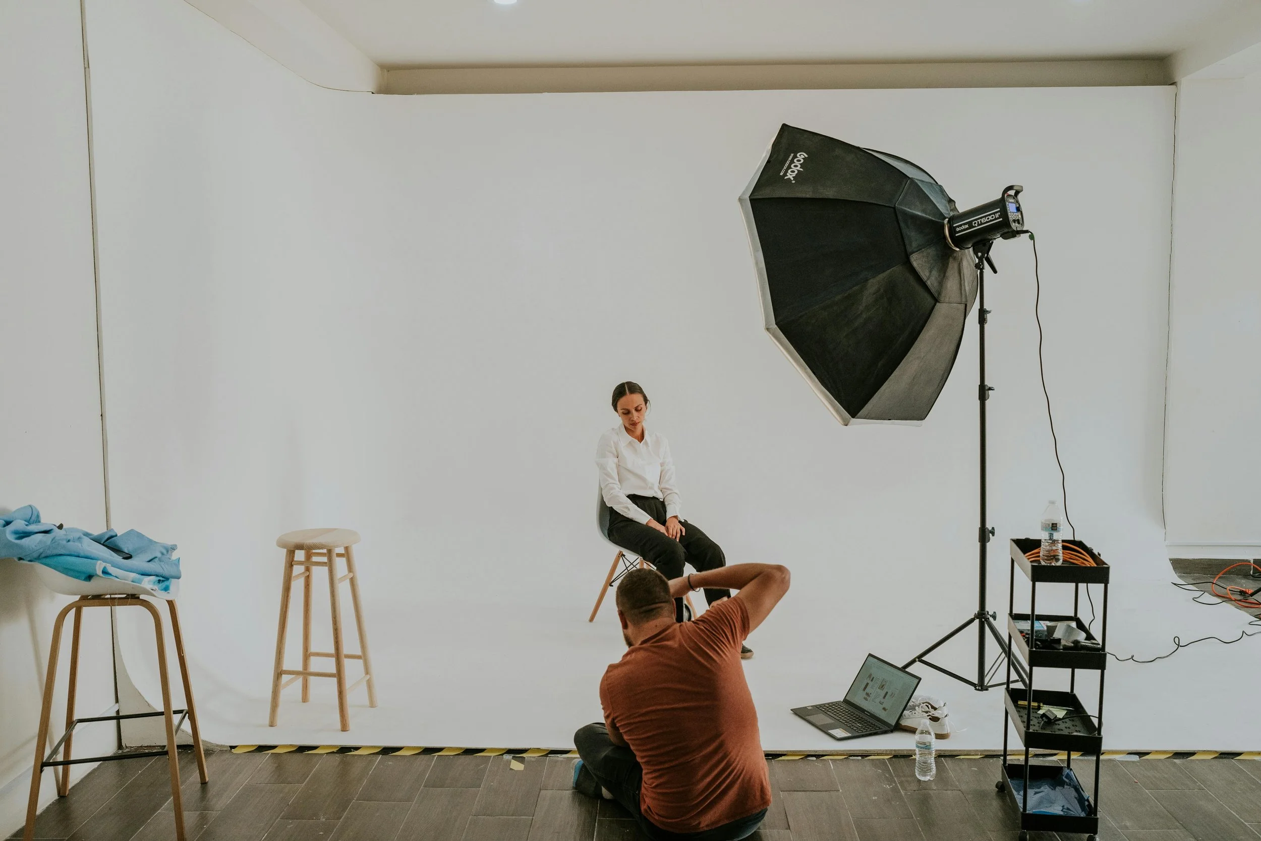 Male photographer taking a picture of a women in the photography studio
