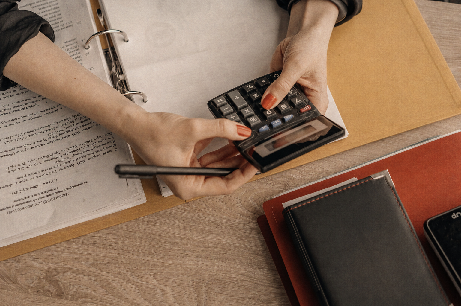 A photographer sits down with a calculator to review mileage records and business expenses.