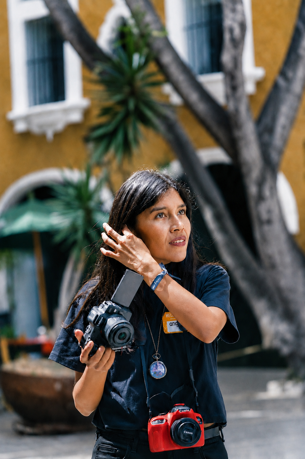A busy photographer carries multiple cameras while preparing for her next session.