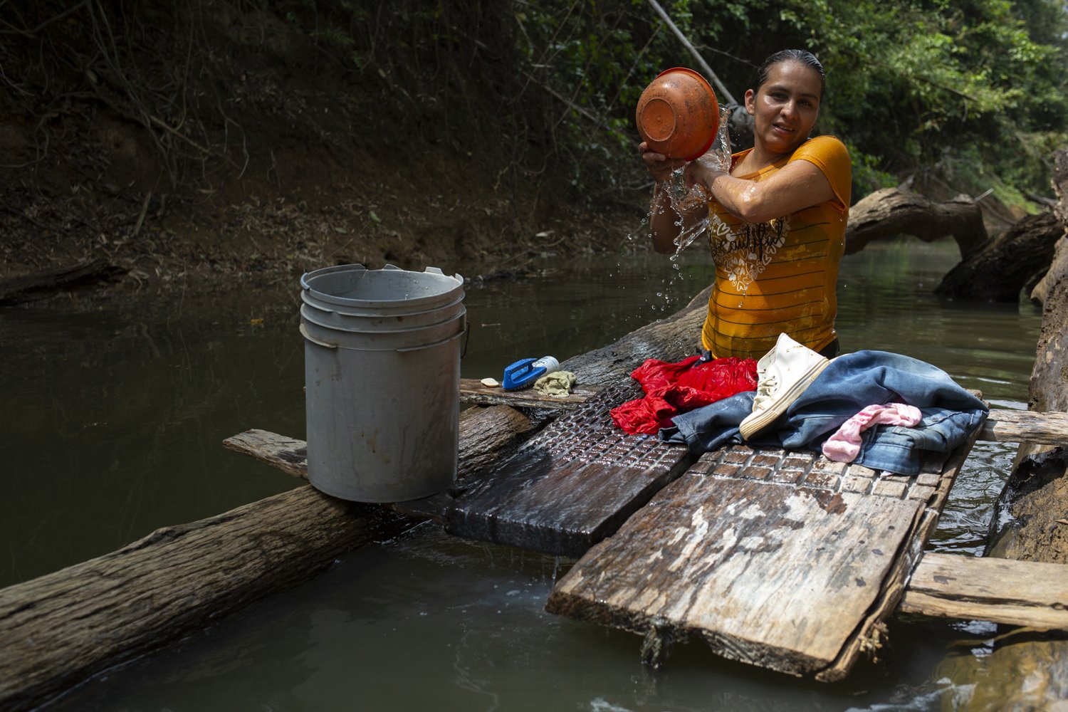  Dora, washes her family’s clothes and bathes in the gully behind her house in Colombia’s rural Guayabero region. Dora has received training in journalism from a local media collective, but says it’s been impossible to find the time to report–or even