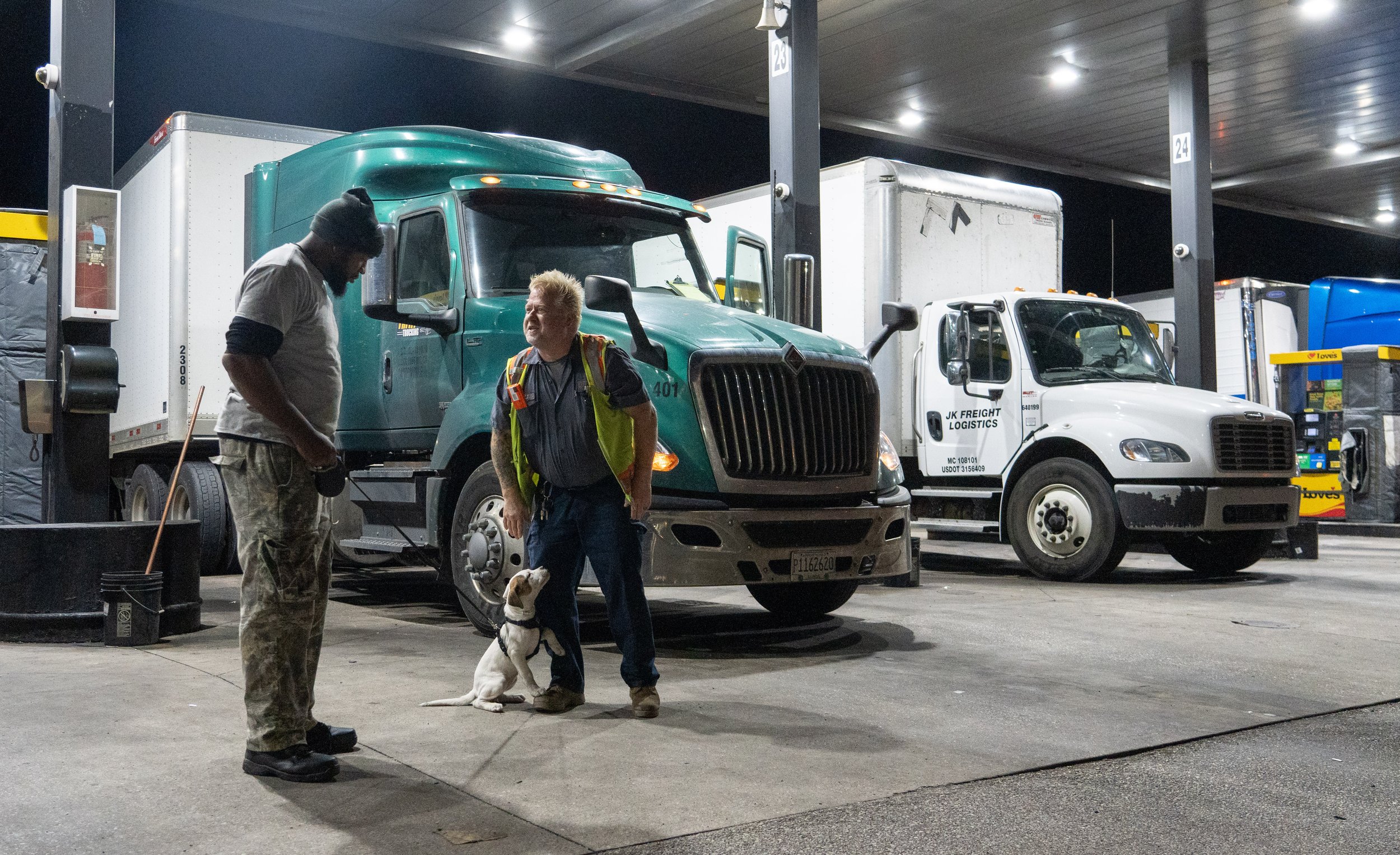  J.J.Pearson visits with a fellow truck driver and his puppy at a truck stop in the early morning hours of Friday, Nov. 3, 2023. 