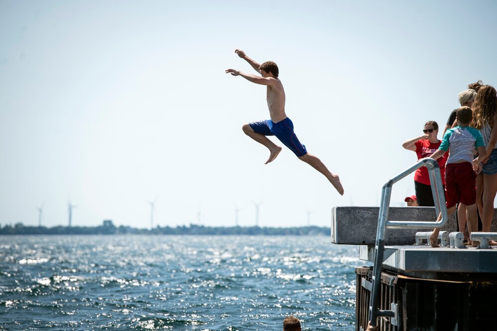 Leaping into Lake Ontario from the Gord Edgar Downie pier in Kingston, Ontario.