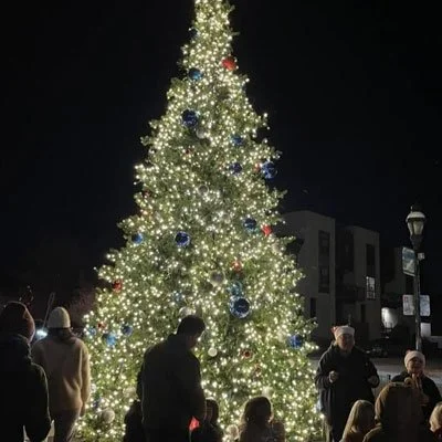 A crowd gathers around a Christmas tree at the Highlands Square Market
