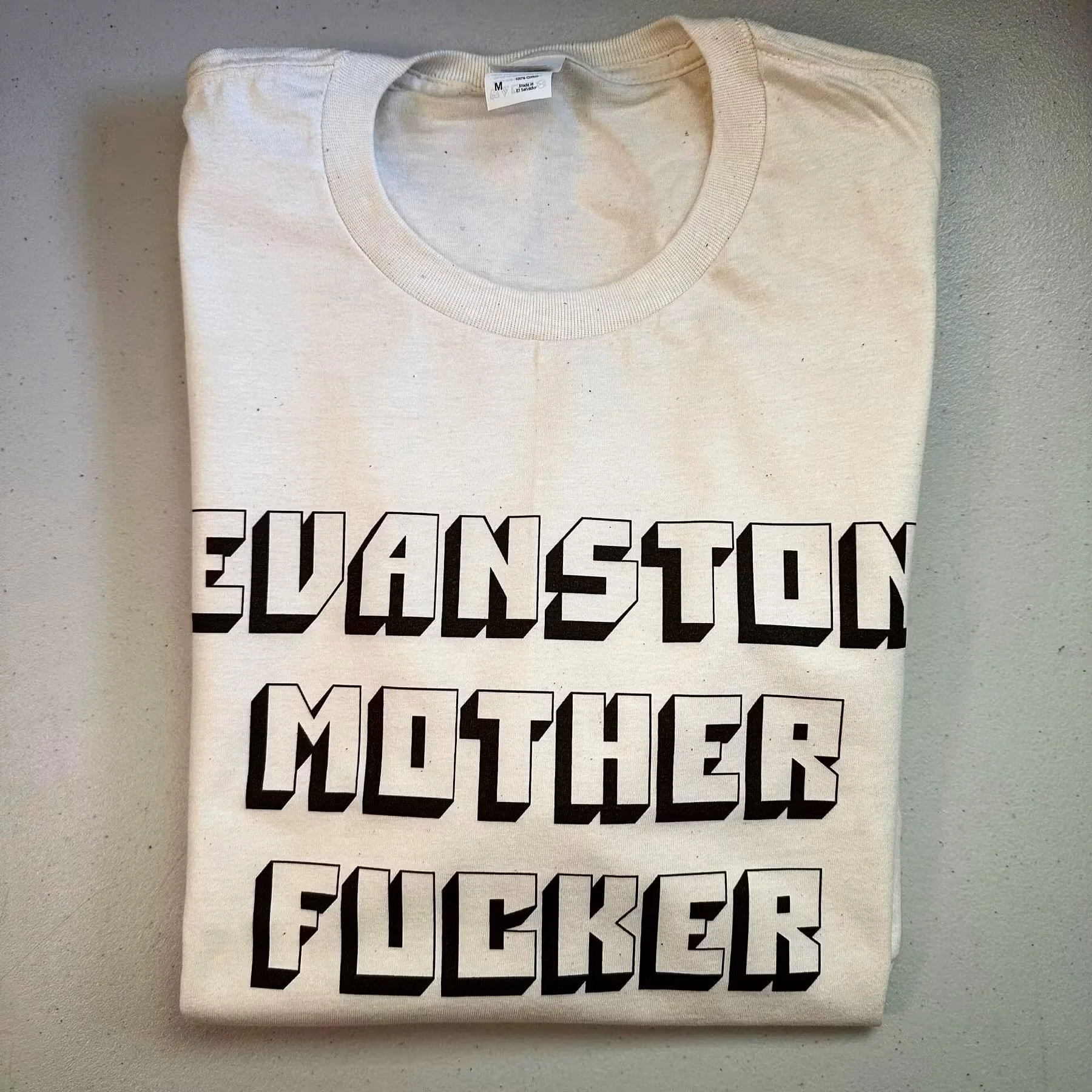 Evanston Mother F*cker 
Natural Tee 
.
https://goaheadmerch.com/evanston/evanston-mother-fucker-tshirt