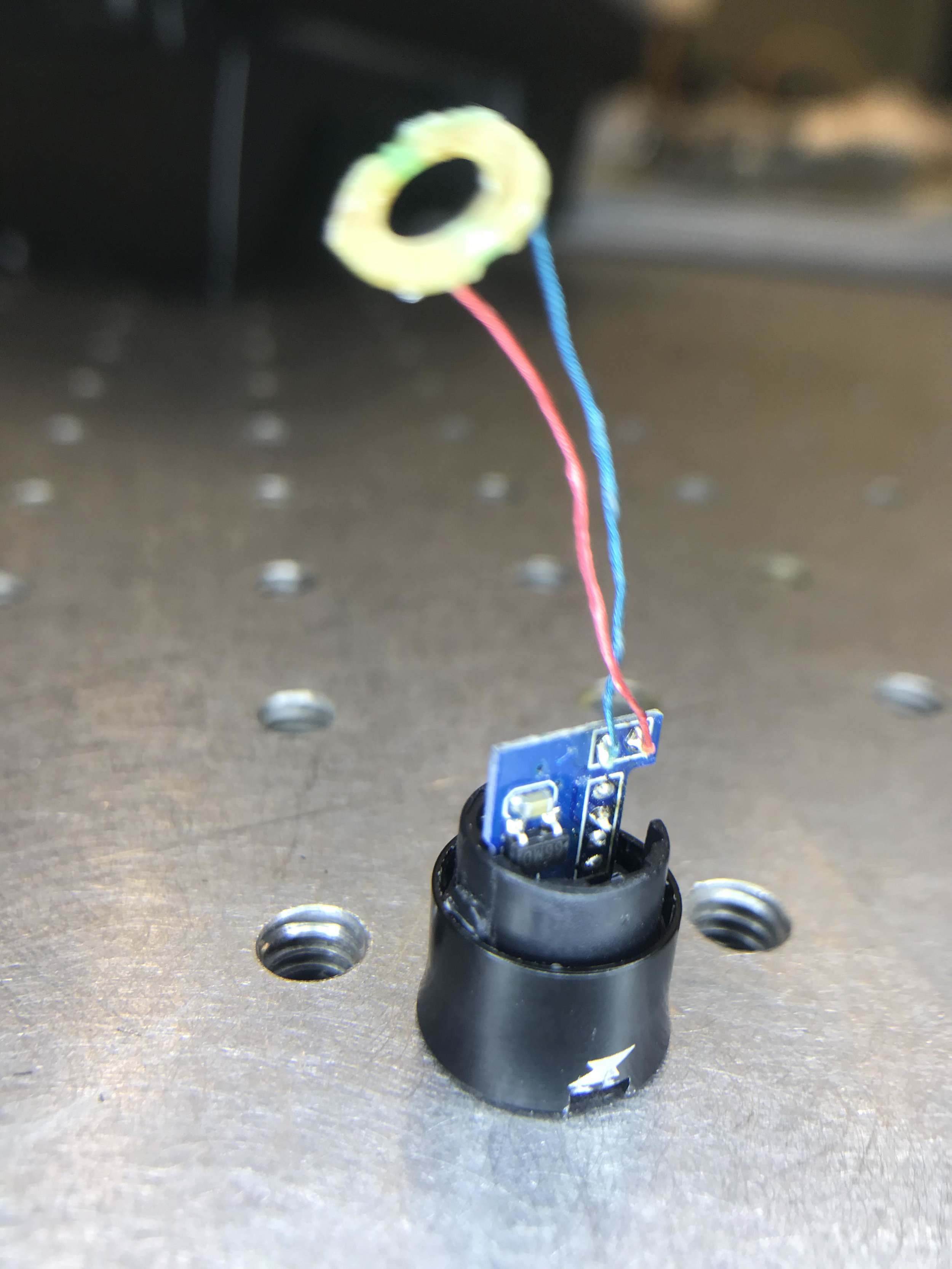 Right earbud before disassembly showing the power contacts that charge the device