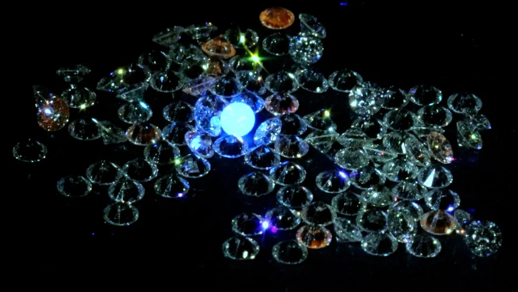 mined diamonds glow blue in a parcel of lab grown diamonds