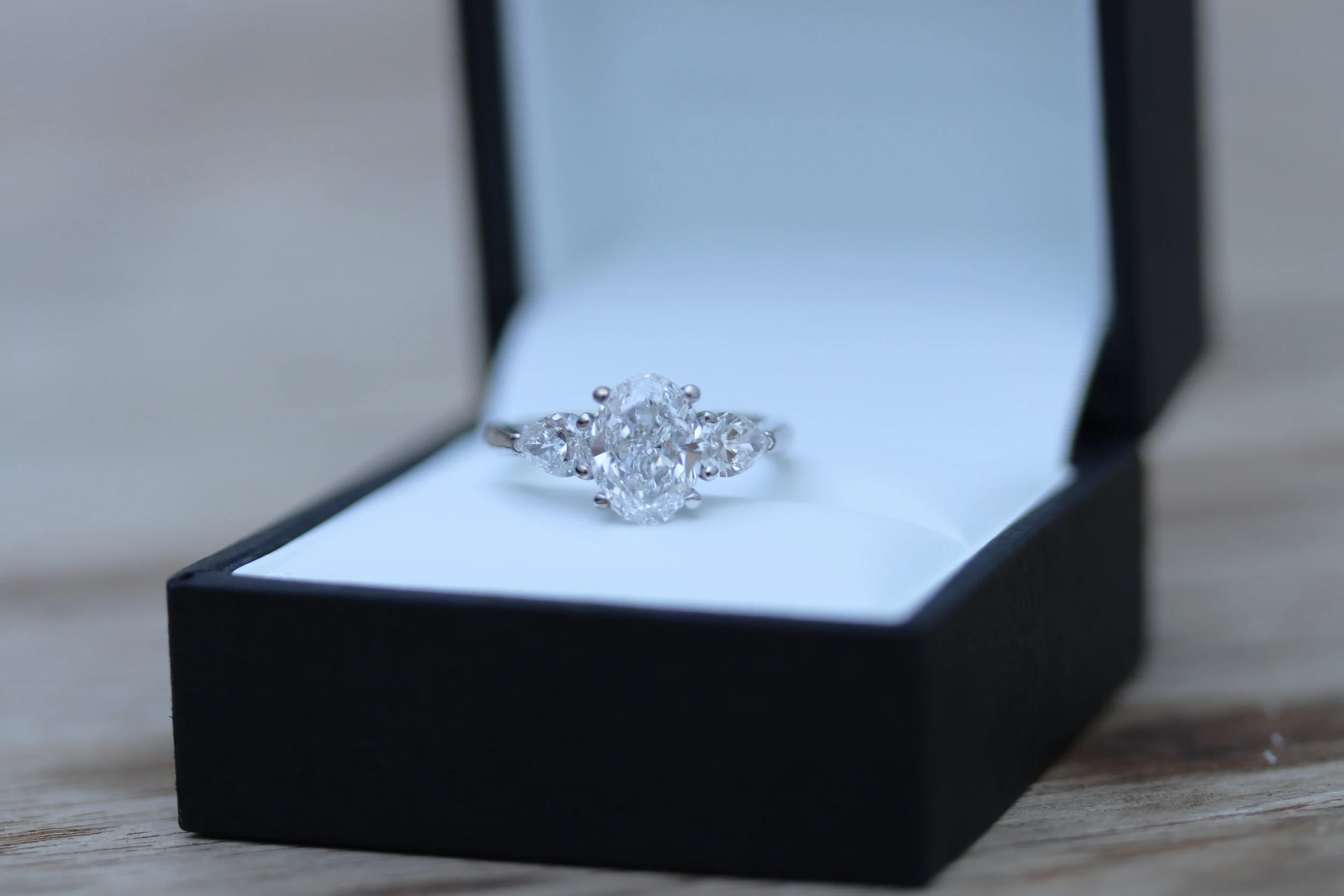 oval lab diamond three stone engagement ring with round brilliant side stones