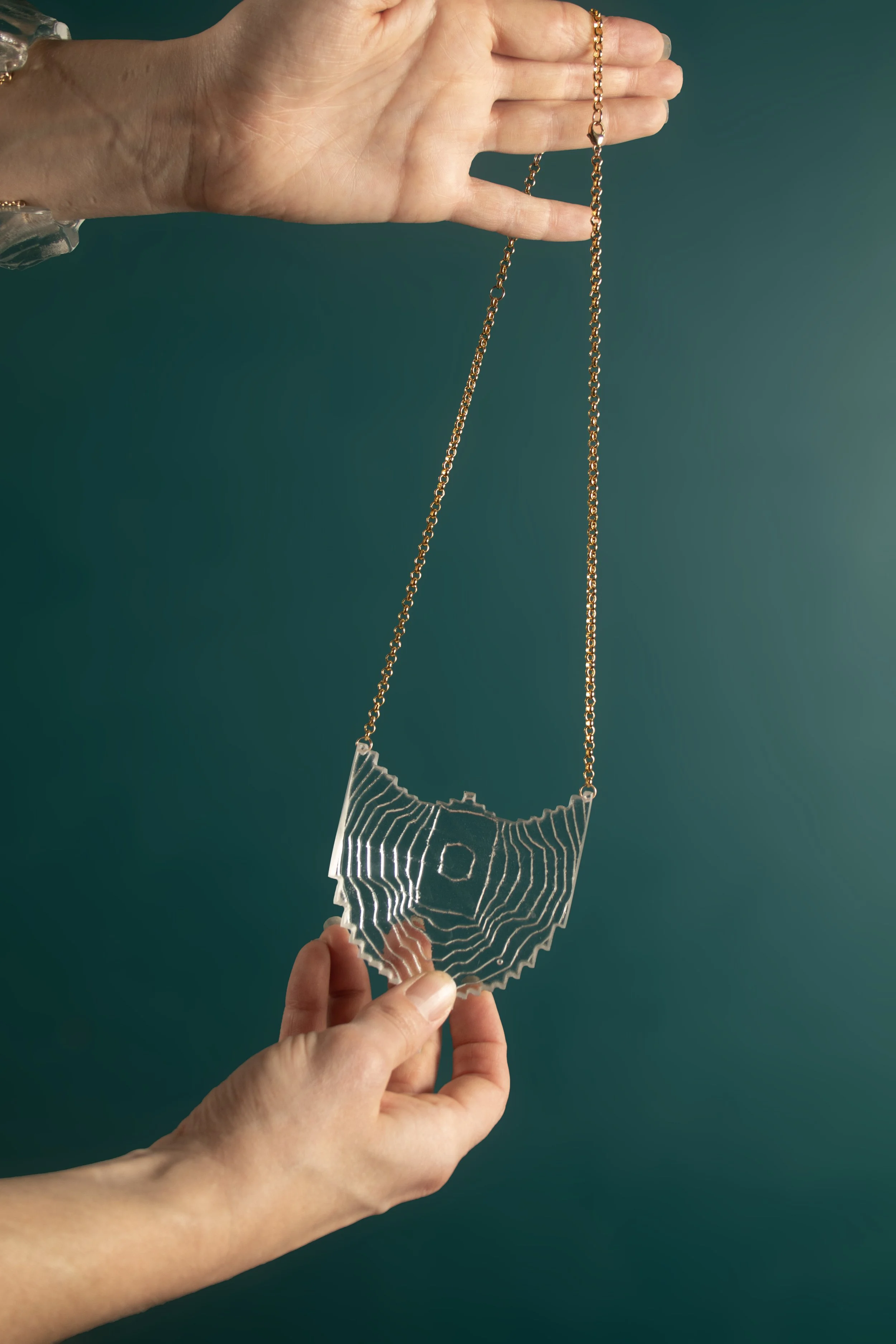 PendantTextureShieldinClear_back_onteal.jpg