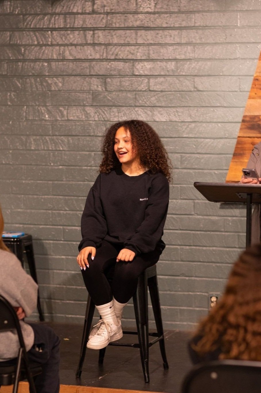  A young girl seated on stool with Youth ministry group 