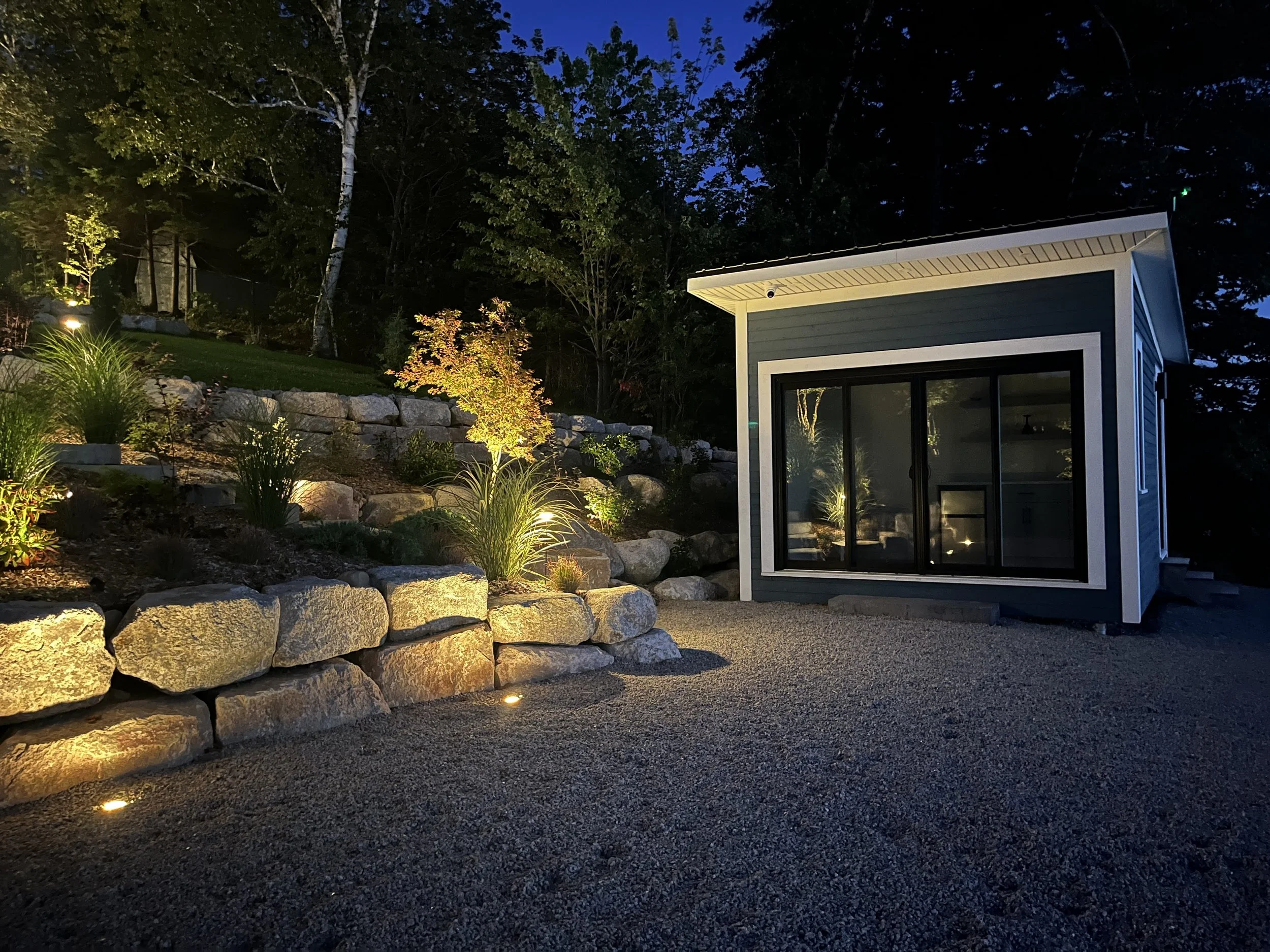 I designed the boathouse to have a wetbar & seasonal kitchen, the access lit by bounced light from the granite retaining wall & spill from uplighting the nearby speciment, a variegated 'First Ghost' Japanese Maple.