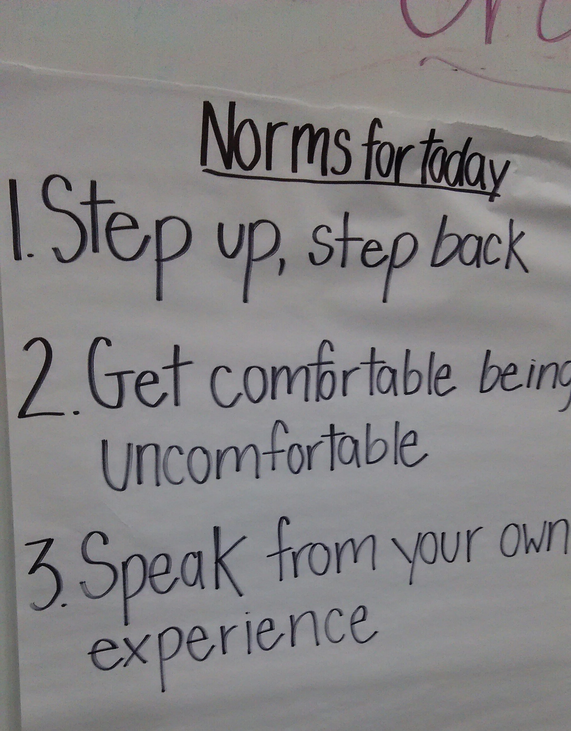 [Image description: A handwritten poster from a SURJ meeting reads: “Norms for today (underlined) 1. Step up, step back 2. Get comfortable being uncomfortable 3. Speak from your own experience]
