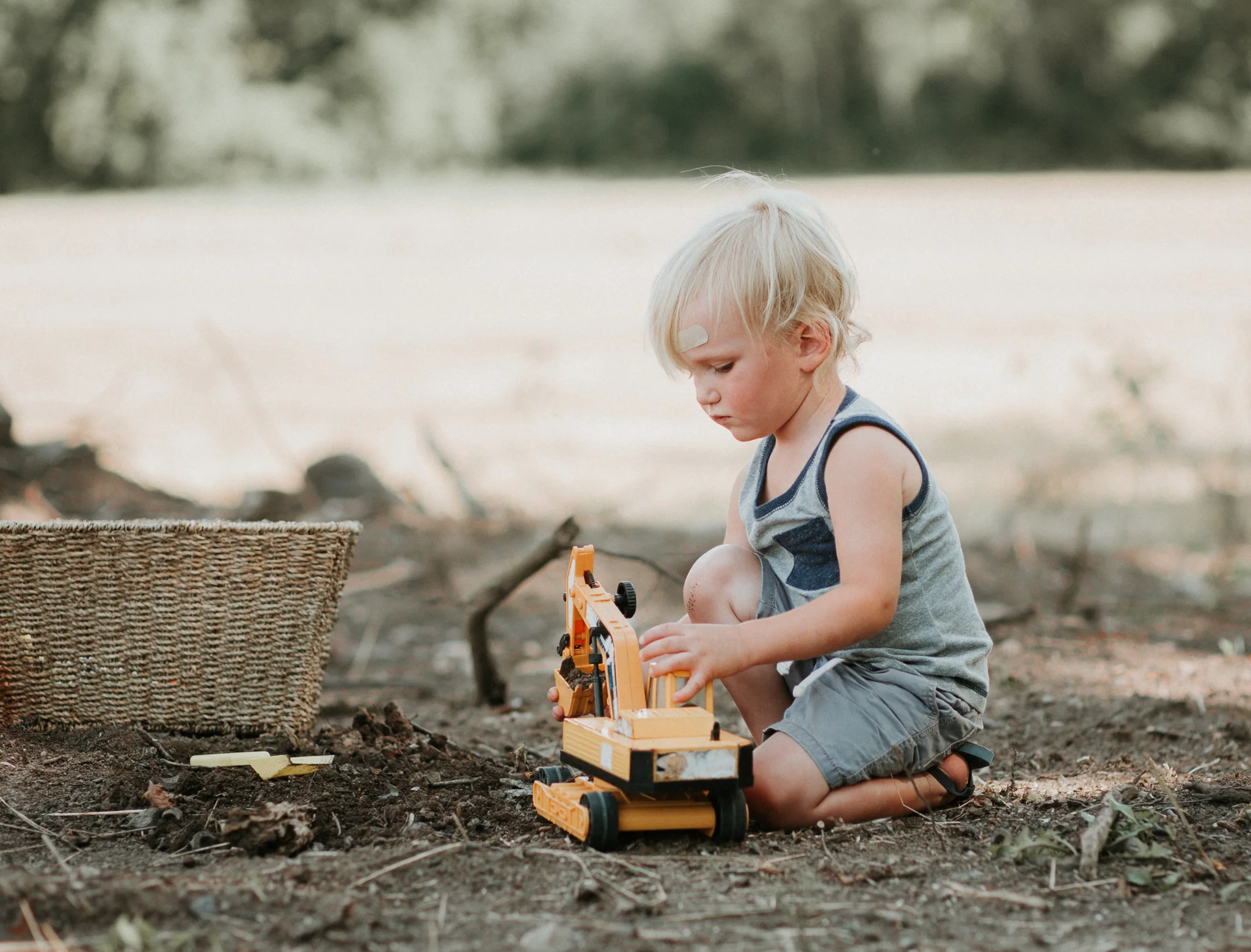 boy playing with toy excavator in dirt