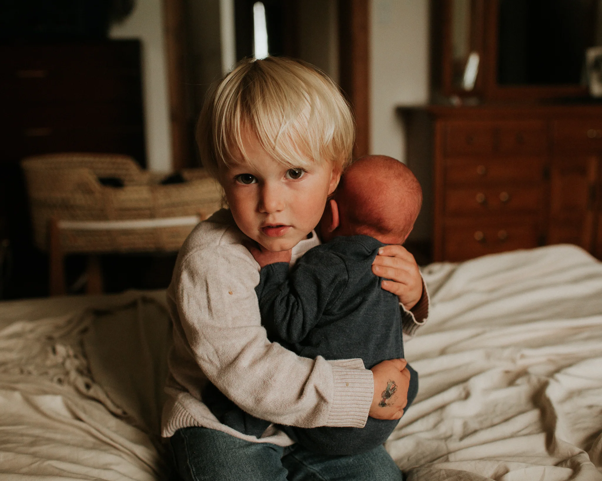little boy holding newborn