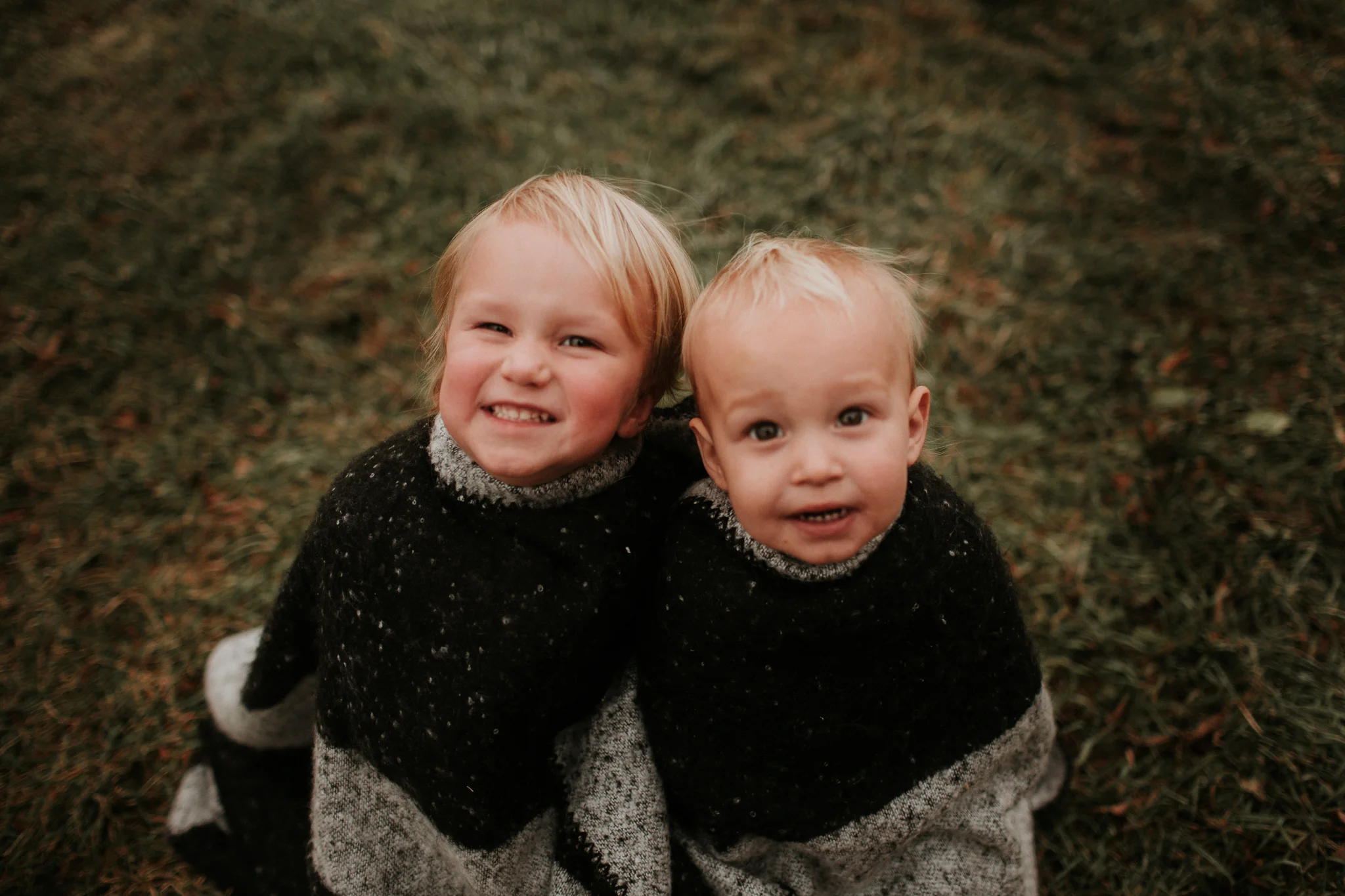 brothers snuggled in blanket