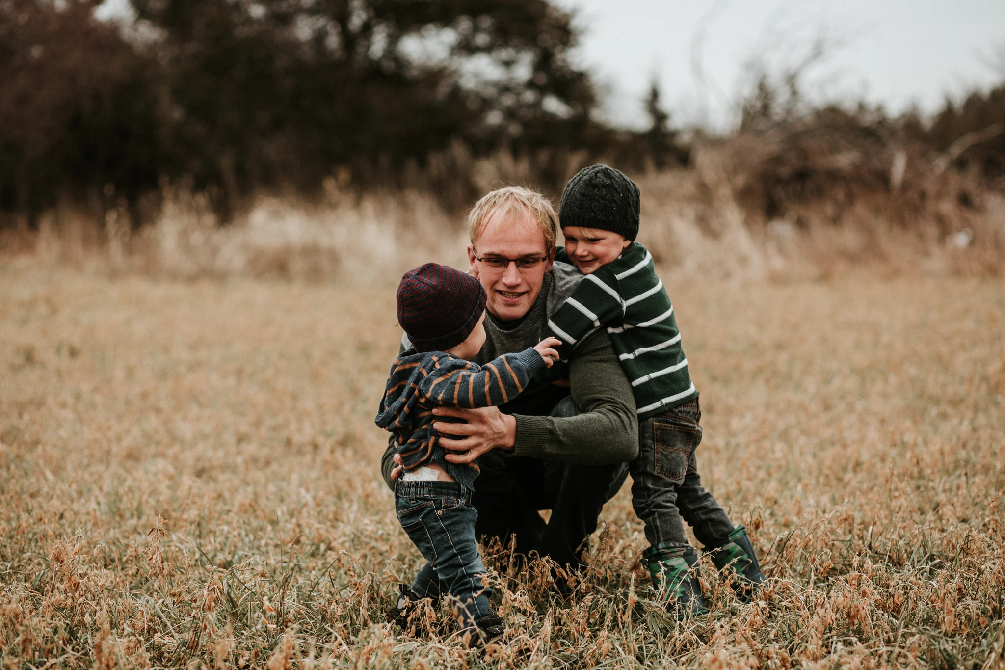 dad and sons playing in field