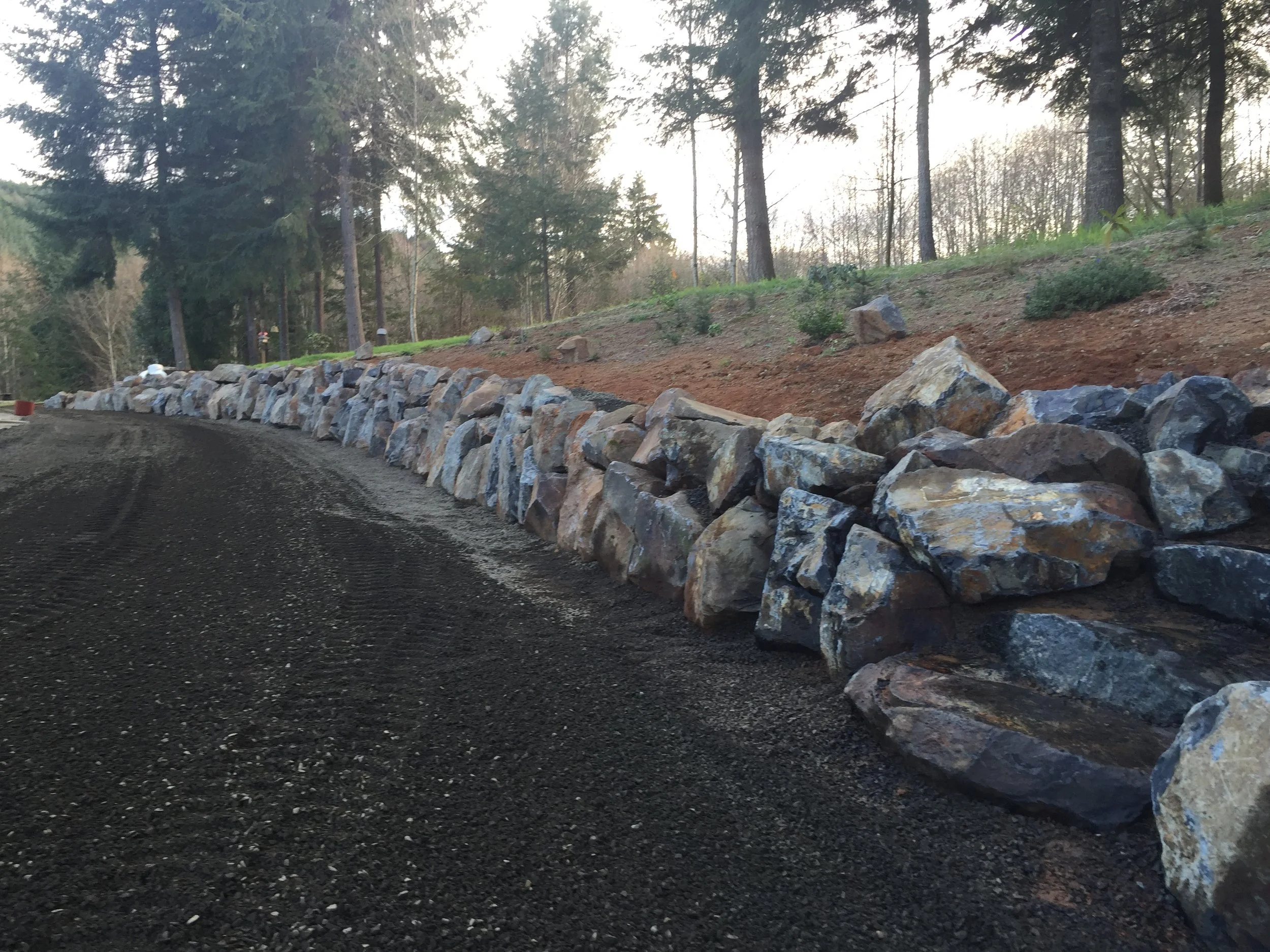 Boulder rock retaining wall built by Columbia Groundwork along a driveway in Cowlitz County, WA