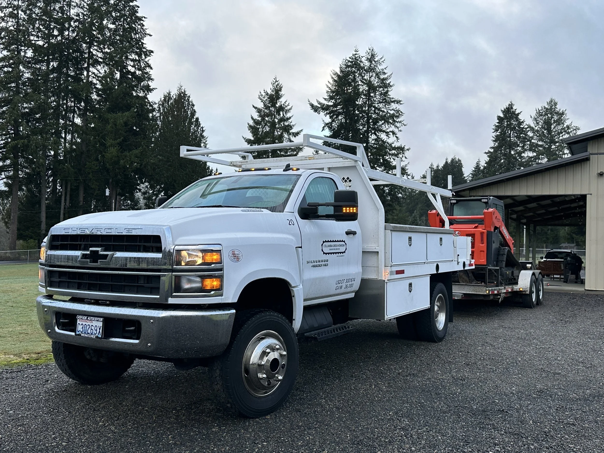 Columbia Groundwork truck hauling equipment on a trailer
