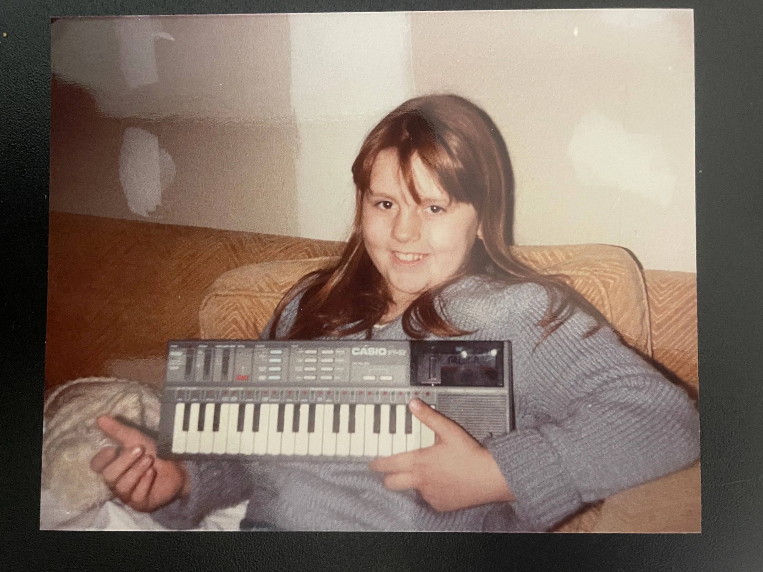 Meag as a child holding her new electric keyboard on Christmas
