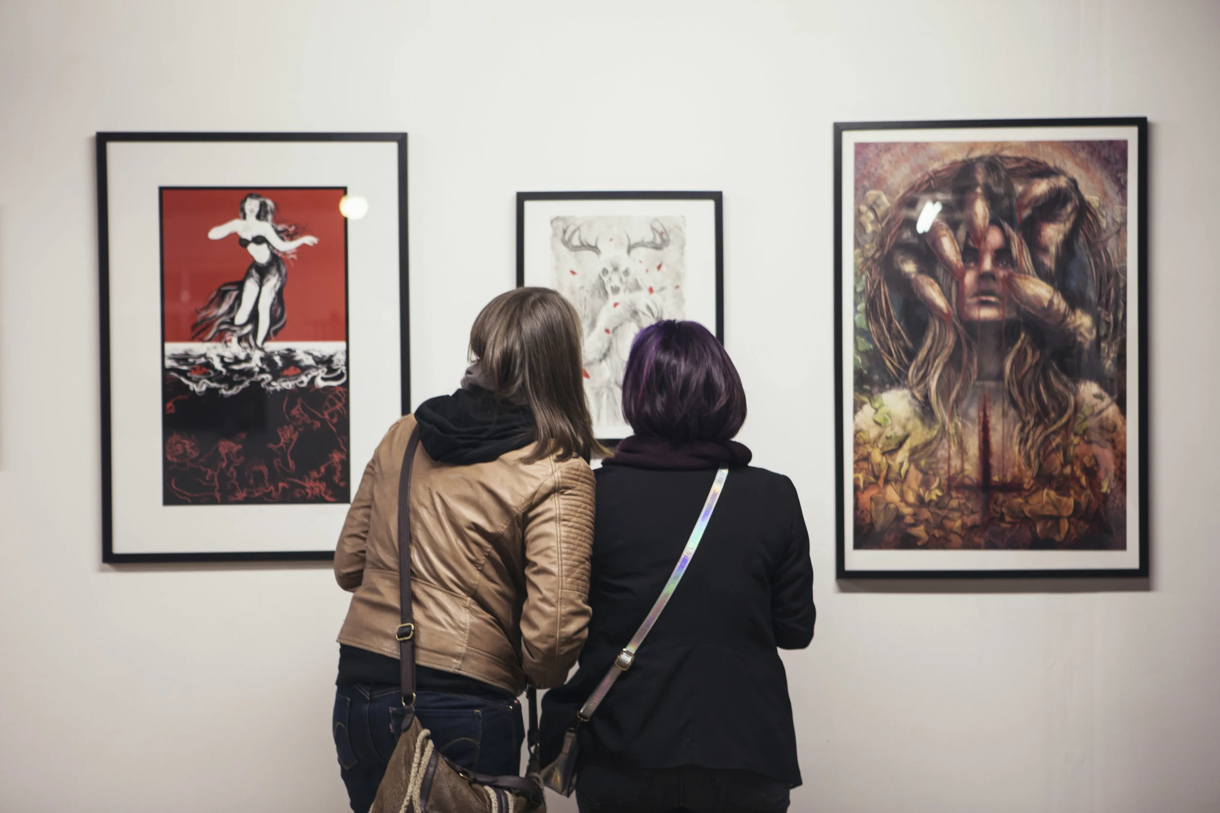 Visitors admire original artwork by Ben Templesmith in the HERETICS exhibition - Photo by Kirsty Garland.jpg