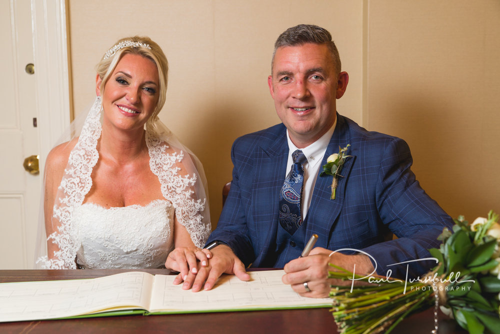 Bride and Groom Signing Register at Harrogate Register Office. Bride and groom at Harrogate Register Office. Wedding Photographer Yorkshire