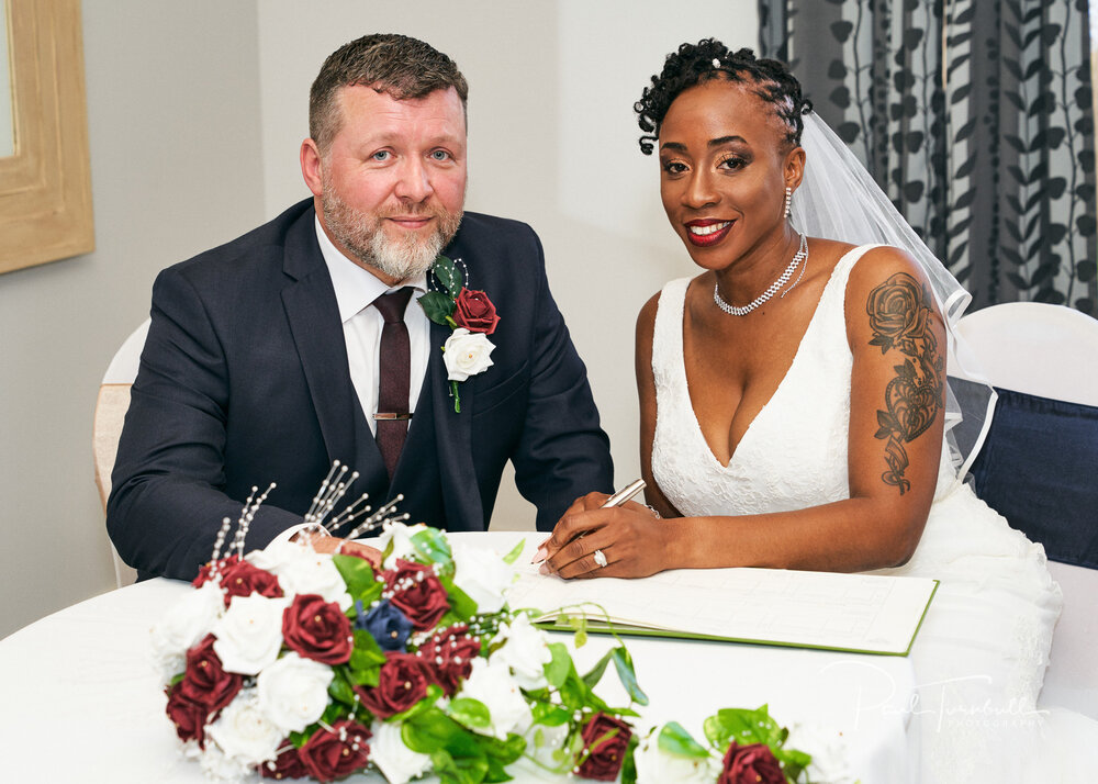 Bride and groom signing the register at Lazaat Hotel. Wedding photographer Hull