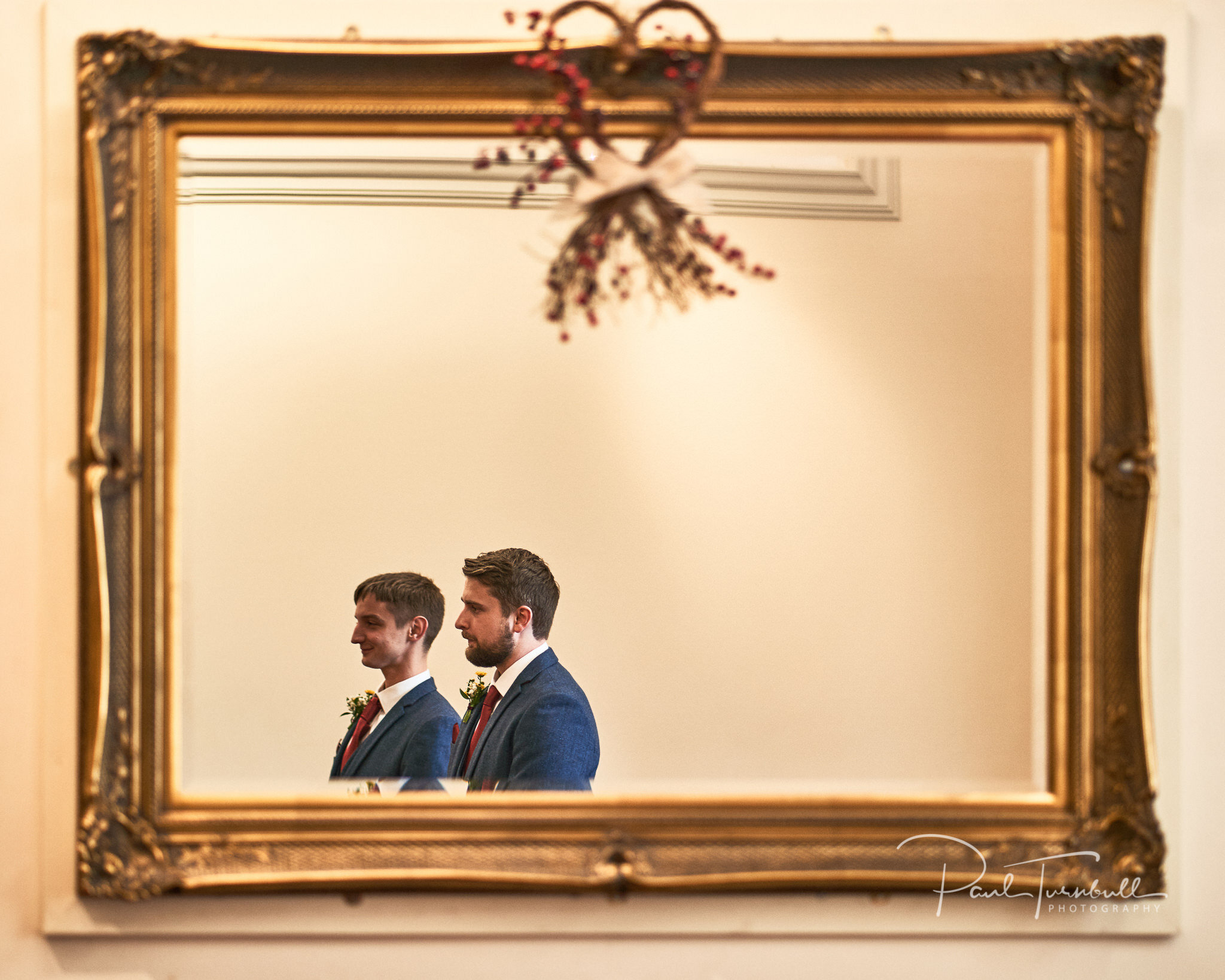 Groom and Best Man Framed in Mirror. Wedding Photography at Sheffield Town Hall