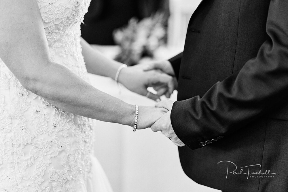 Black and White. Bride and groom holding hands during Old Swan Hotel wedding ceremony