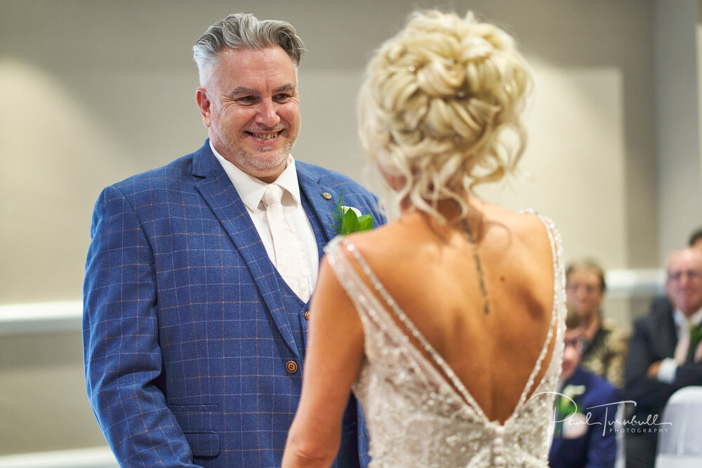 The Groom Smiles at the Bride During Ceremony