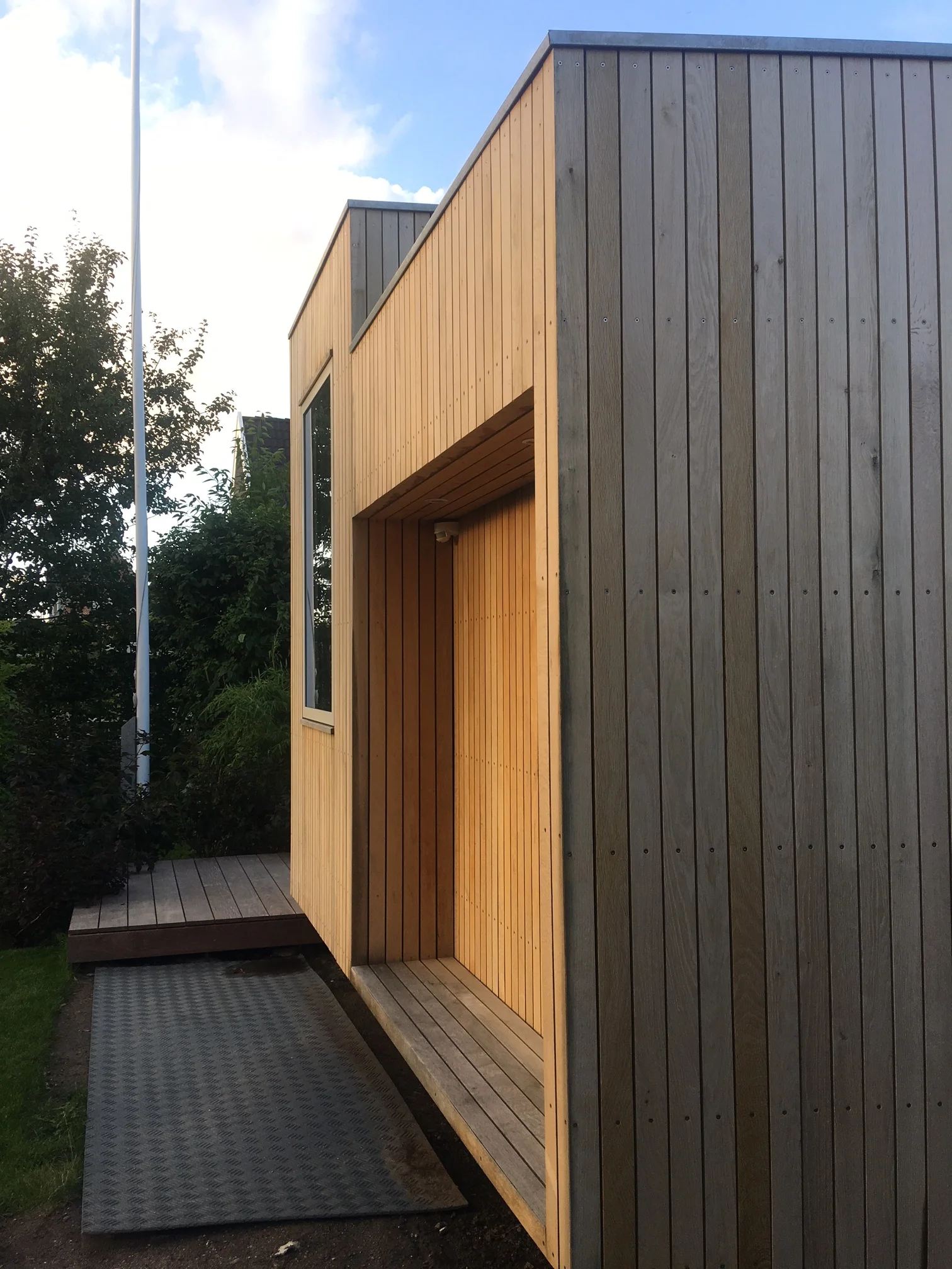  En del af facaden er "skubbet" tilbage, for at skabe en asymmetri i facaden. Det skaber samtidig et lille rum med en bænk - og om aftenen en lysende kasse. 