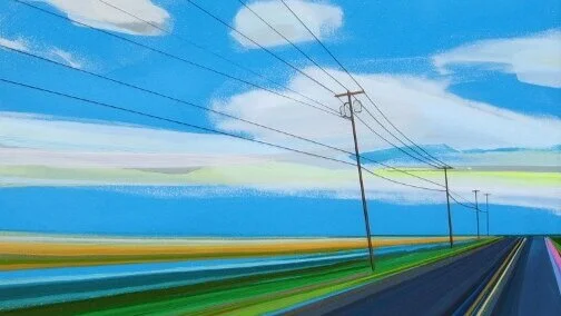 Power lines running along a road with a blue sky and clouds in the background.