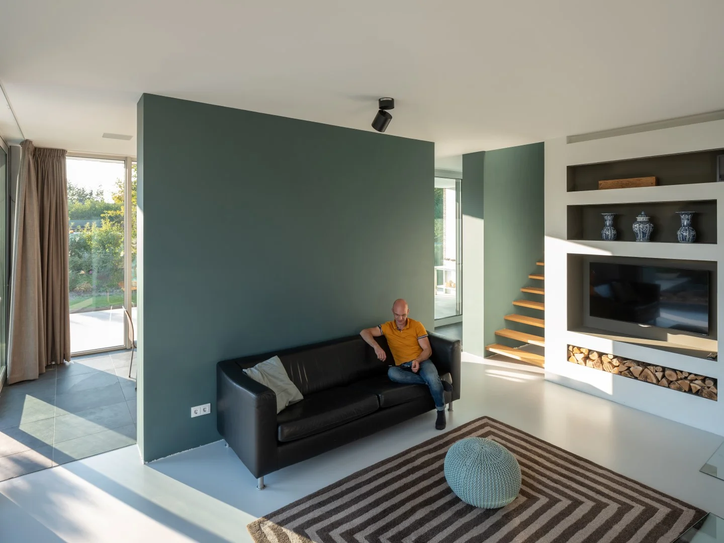 the living room with built in cabinets gives access to the stairs leading up to the second floor