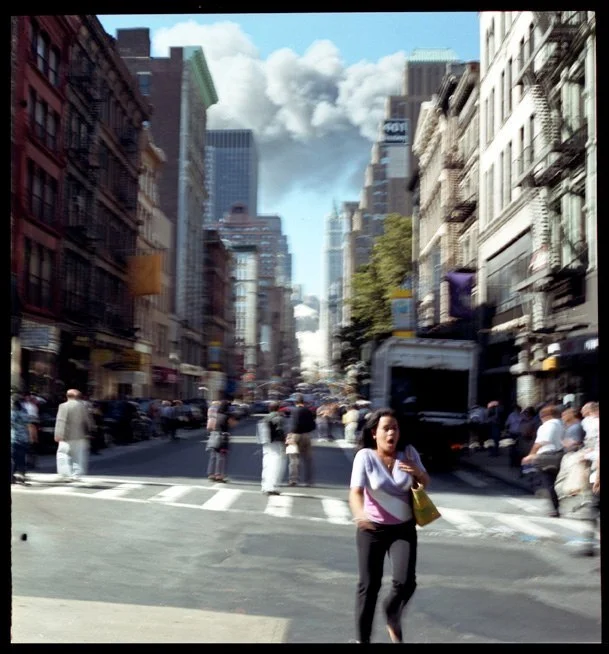 Woman on Broadway runs from the collapse of the first tower in lower Manhattan, September 11, 2001. 