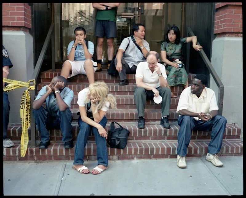 People sitting on stoop in lower Manhattan after the collapse of the two World Trade Center buildings, September 11, 2001. 