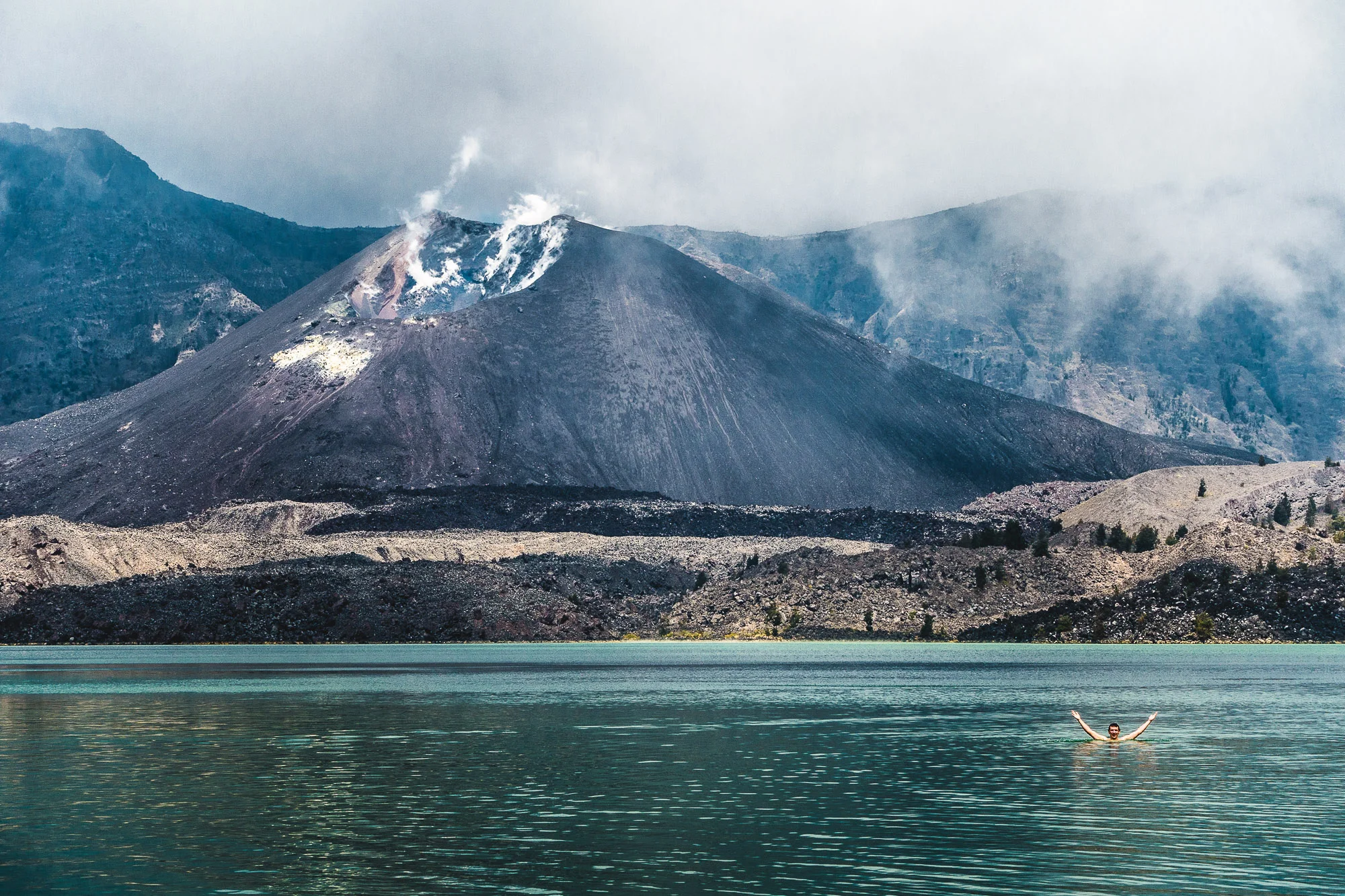 Swimming in front of the Active Volcano Rinjani, Lombok, Indonesia