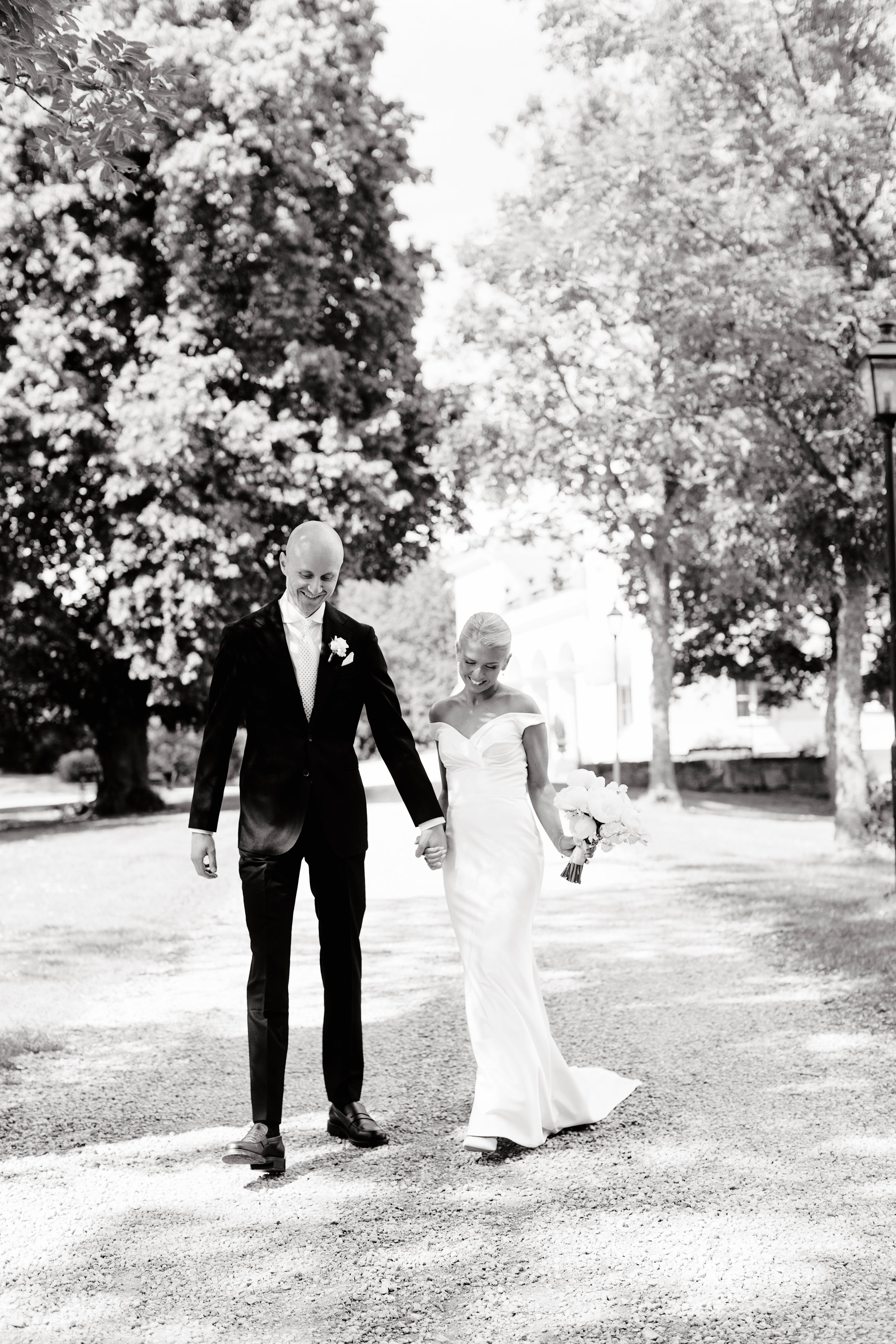 Svartvit bild på brudpar framför Villa Aske på sitt bröllop fotograferat av Rebecka Rynefelt, bröllopsfotograf i Stockholm.