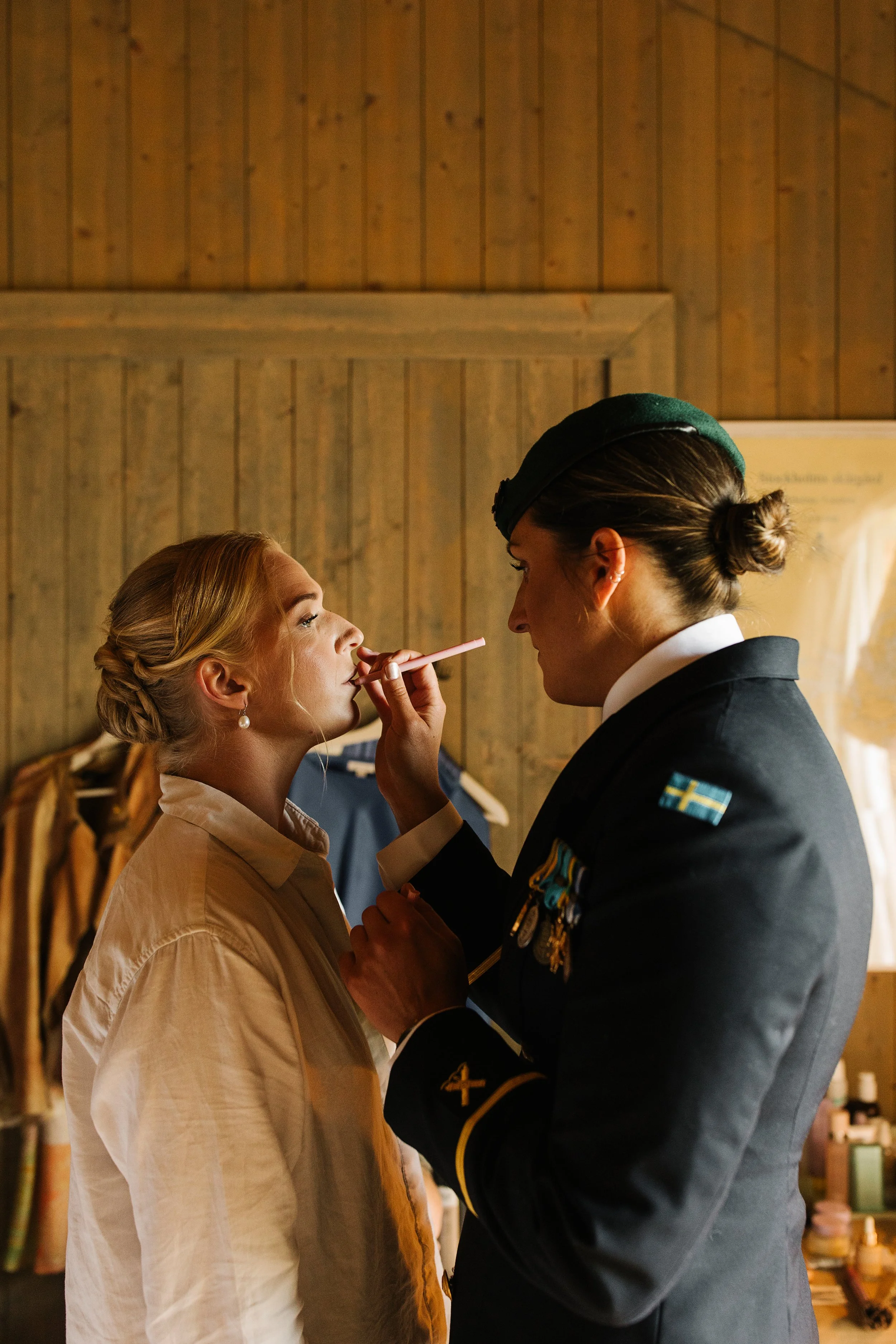 Bröllopsförberedelser för bruden på bröllop på Arholma Nord i Roslagen där bruden blir sminkad av sin vän som är militär, fotograferat av Rebecka Rynefelt, bröllopsfotograf i Stockholm.