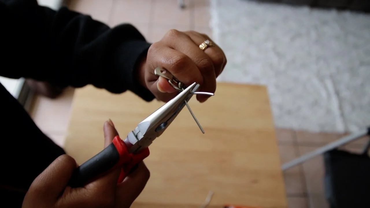 Use the pliers to twist the wire and essentially tie the D-ring to the end of the chain. Cut off any excess wire.