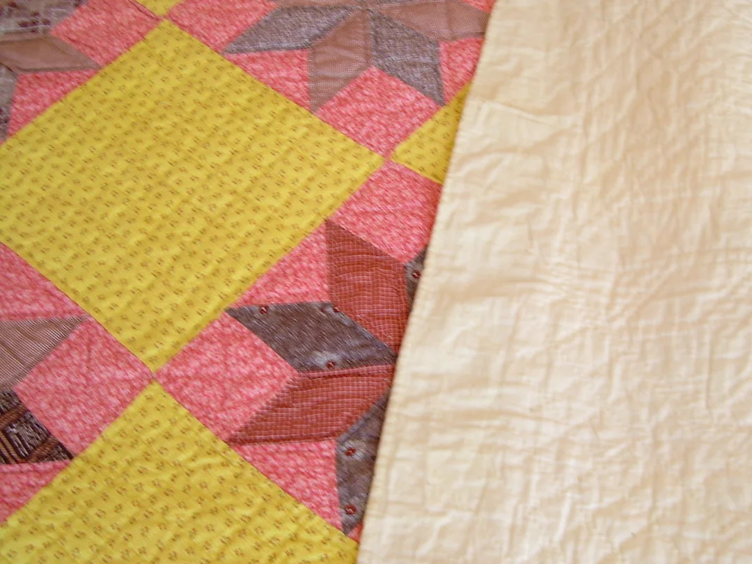 Muslin Backing and Binding on Chrome Yellow and Double Pink Quilt via www.helloquilting.com