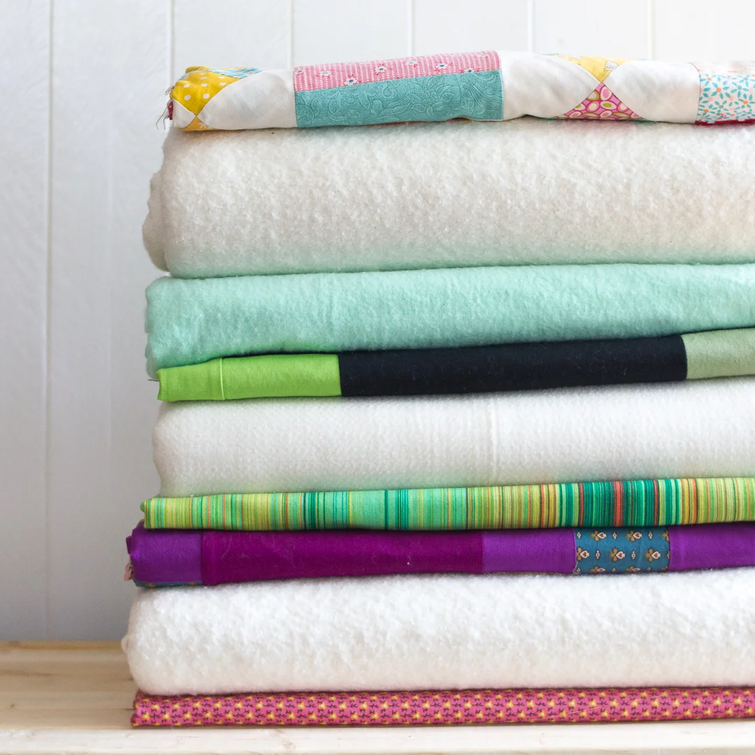 Stack of Quilts Waiting to be Pinned via www.helloquilting.com