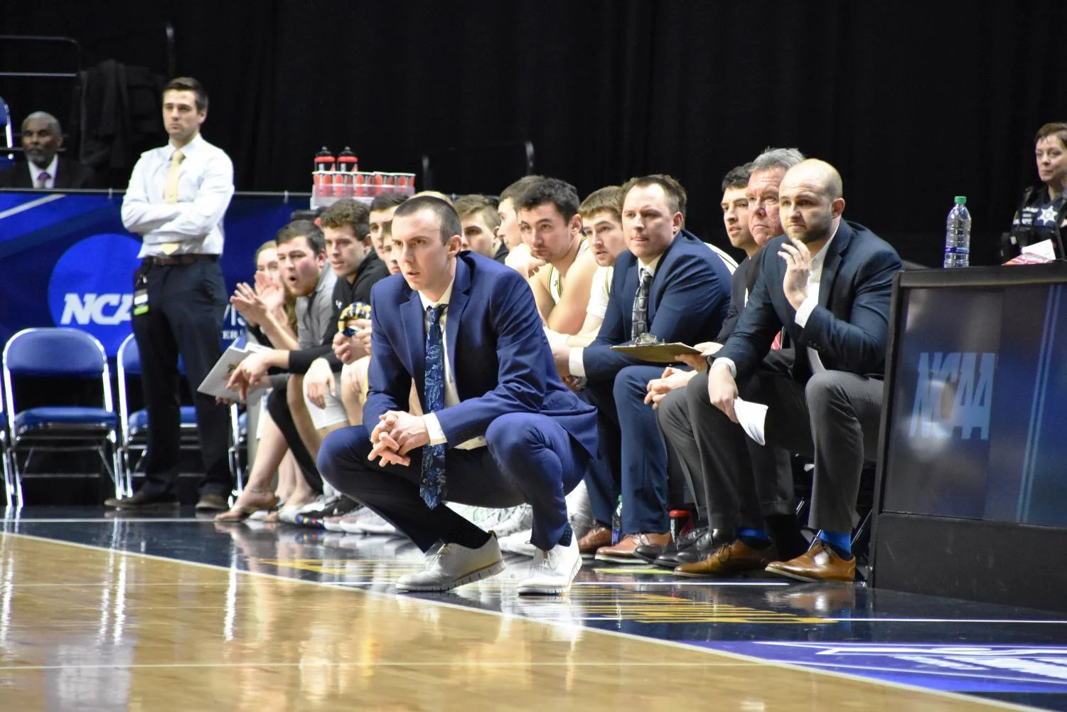 UW Oshkosh Head Coach Matt Lewis crouches during a game in 2019. Credit: Lydia Sanchez, The Advance Titan