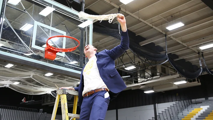 Matt Lewis cuts down the net after winning the NCAA D3 National Championship in 2019. Credit: Liz Smith, UW Oshkosh Today.