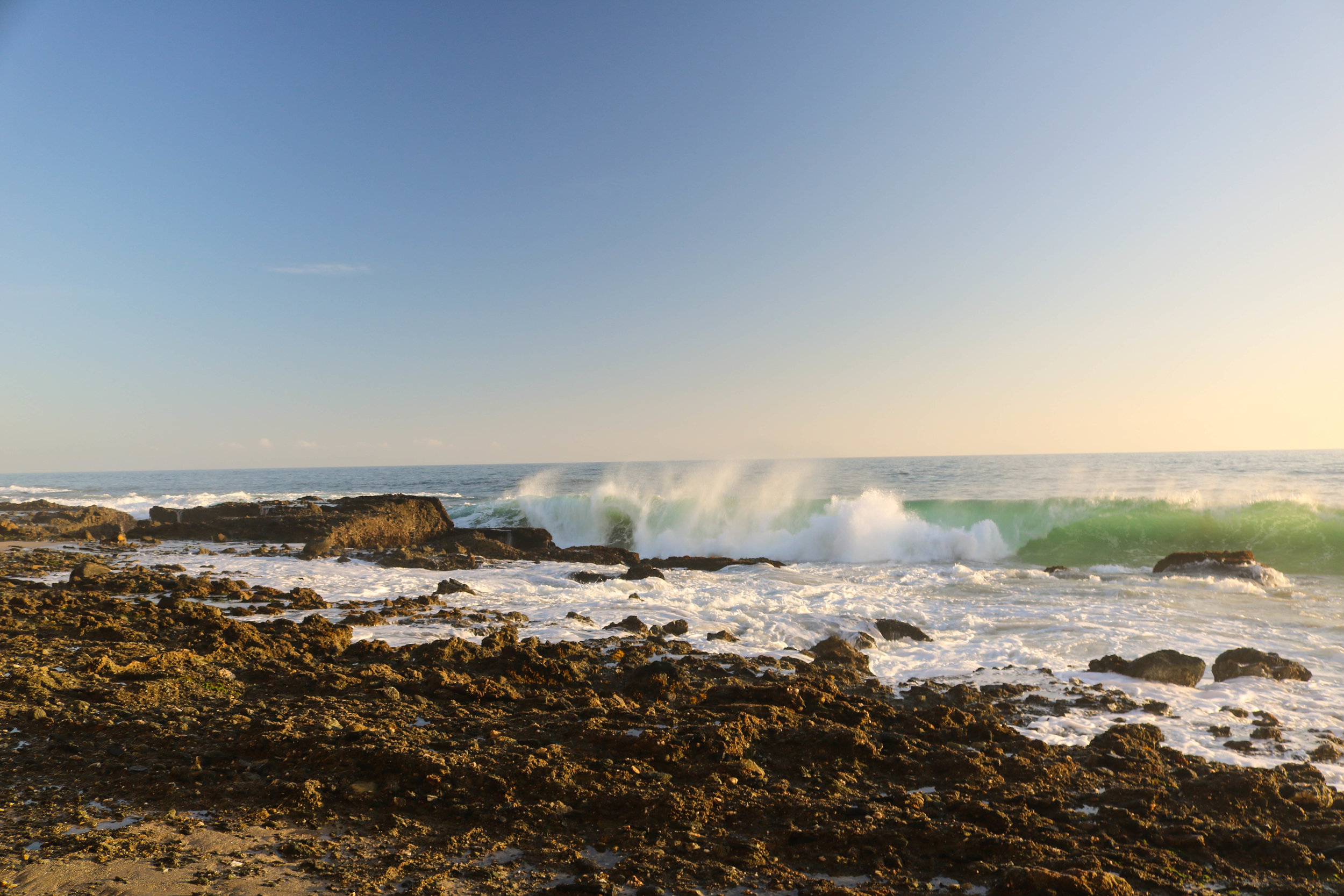 Wave breaking om rocks.jpg