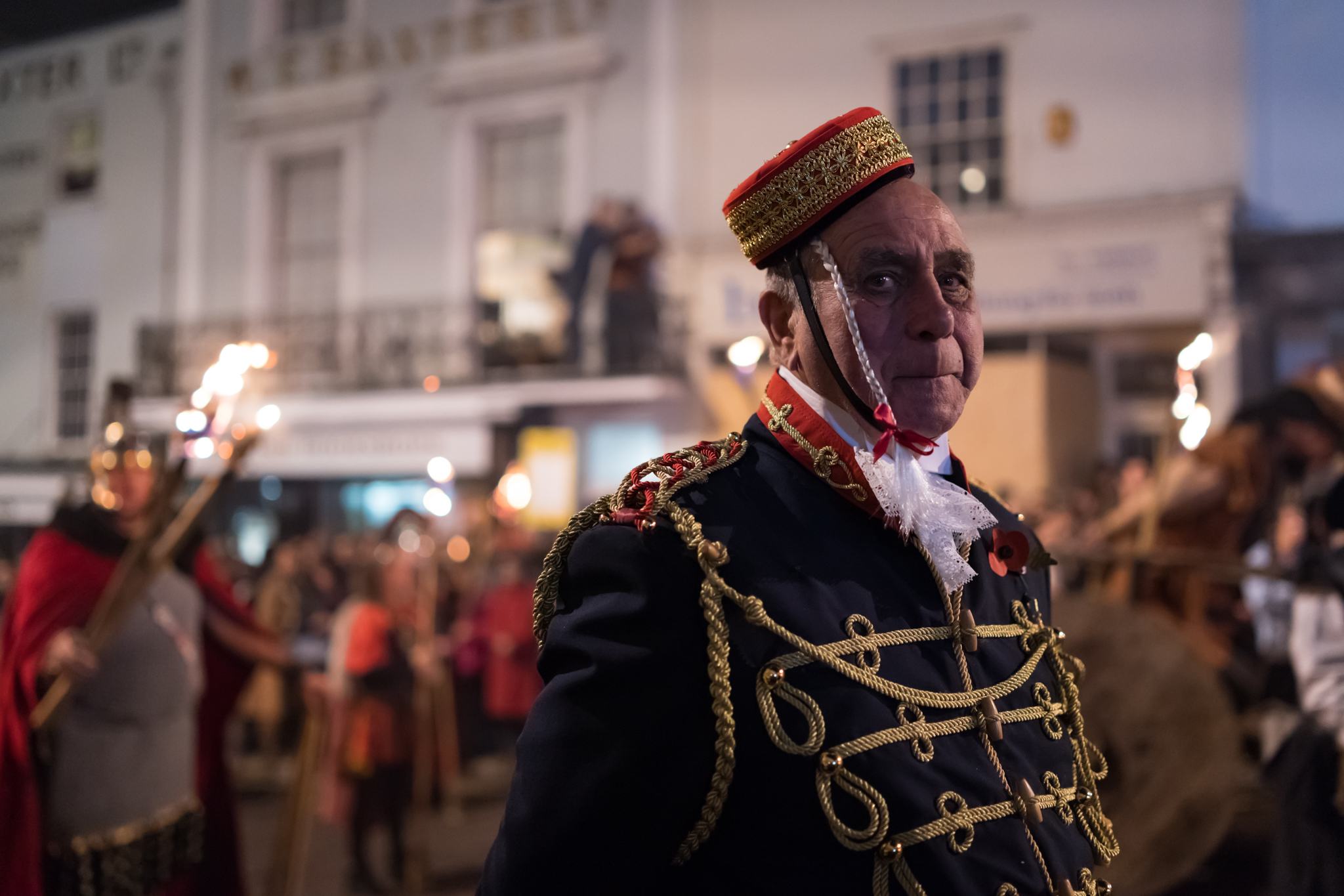 A man in one of many historical costumes worn by society members parading through the streets carrying torches, effigies and burning crosses