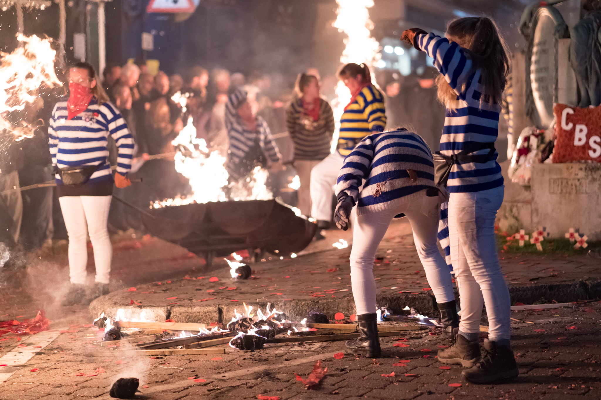 Gathering discarded torches and putting out small fires along the way